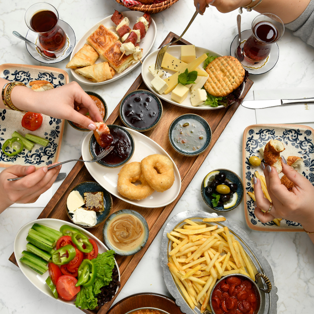 Reichhaltige Mado-Frühstücksplatte mit Käse, Oliven und warmen Beilagen